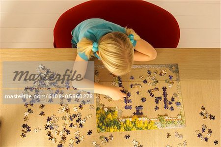 High angle view of a girl playing a jigsaw puzzle High angle view of a girl playing a jigsaw puzzle