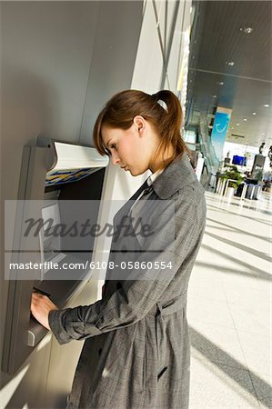 Side profile of a businesswoman using an ATM