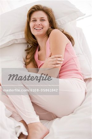 Woman resting on the bed and smiling