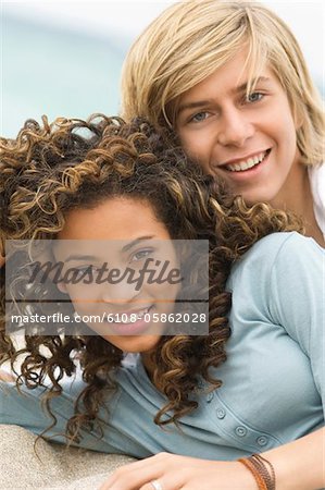 Portrait of a teenage boy with a girl on the beach