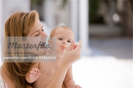 Woman giving medicine to her daughter