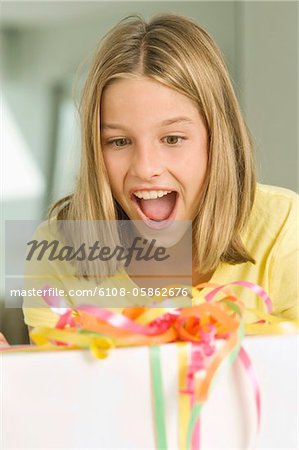 Girl looking at a birthday present with a surprise