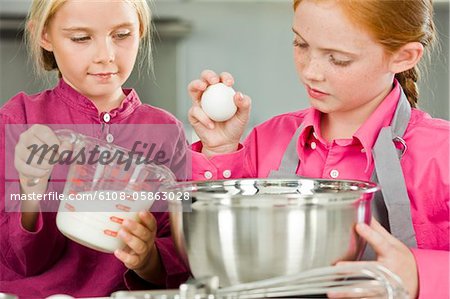 Two girls cooking food in the kitchen