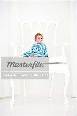 Baby boy sitting in an armchair