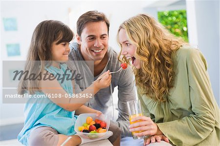 Girl feeding fruit salad to her mother