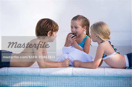 Two girls and a boy at the poolside