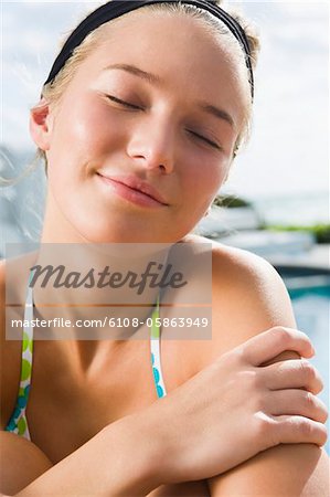 Woman day dreaming at the poolside