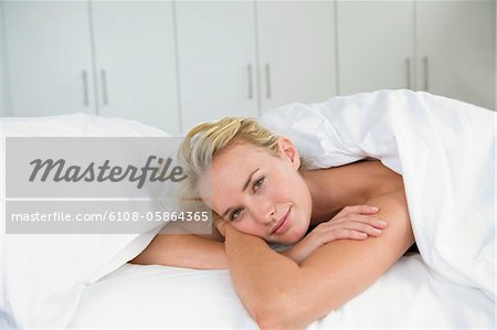 Close-up of a woman lying on the bed and smiling