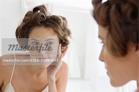 Woman examining her face in the mirror