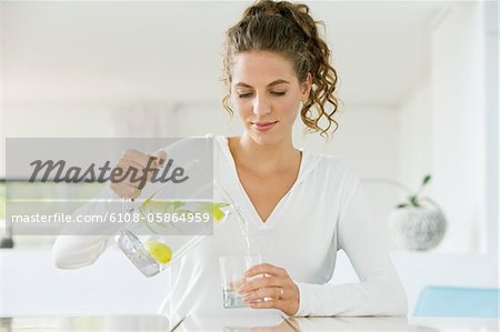 Woman pouring lemonade into a glass from a jug