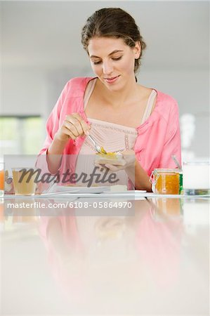 Woman spreading butter on a bread