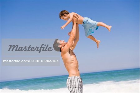 Man playing with his son on the beach