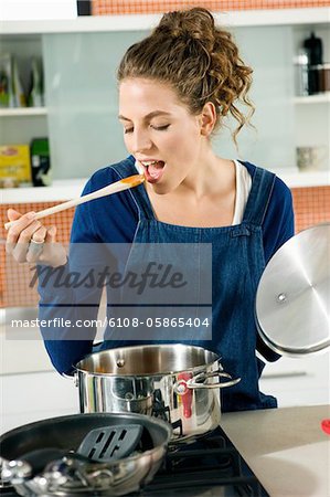 Woman tasting food in the kitchen