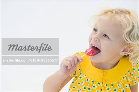 Girl licking red lollipop