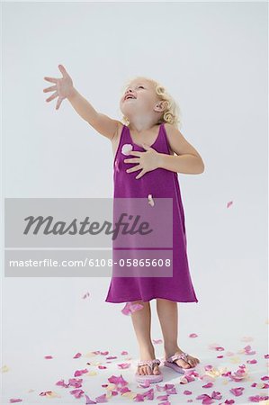 Girl tossing flower petals and smiling