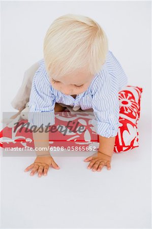 Baby boy crawling on a cushion