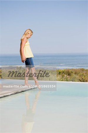 Girl standing on a platform at an infinity pool