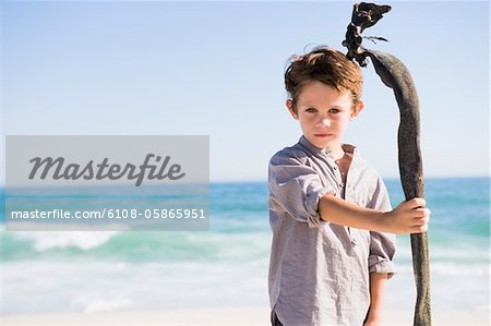 Boy in pirate costume standing on the beach