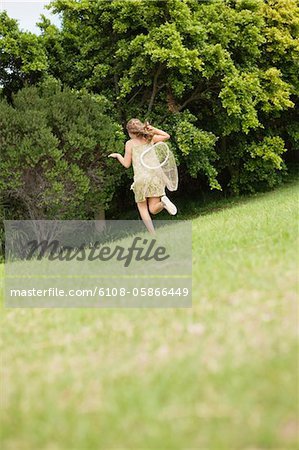 Girl playing with a butterfly net in a garden