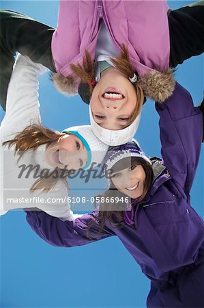 Three teenage girls in ski clothes, smiling at camera