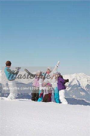 Man taking picture of family in snow