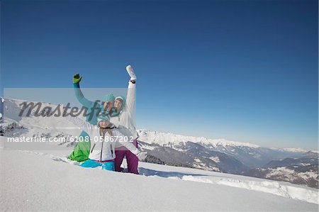 Couple and daughter in ski wear, playing in snow