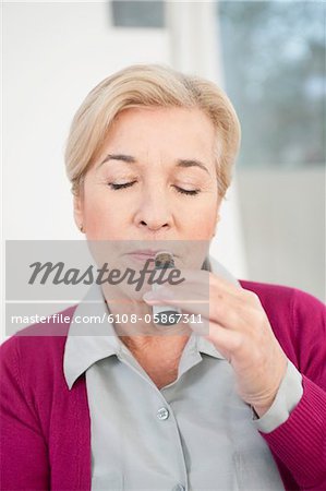 Close-up of a woman smelling aromatherapy oil