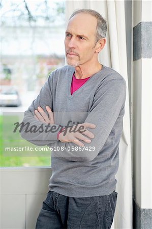 Man standing in front of a window and thinking