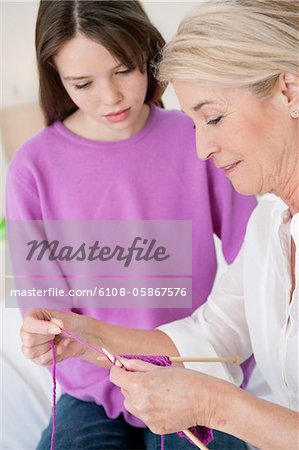 Woman teaching her granddaughter to knit