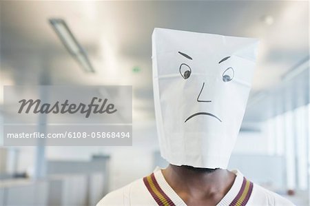 Businessman wearing a paper bag of sad face