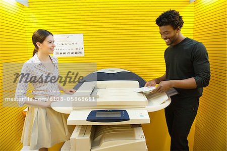 Business executives using photocopy machine in an office