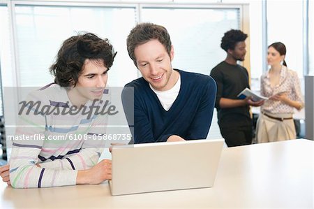 Businessmen using a laptop in an office