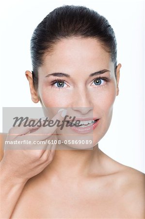 Young woman applying moisturizer