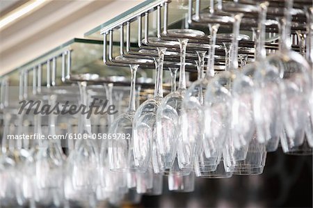 Wine glasses arranged in wine glass stand in a bar