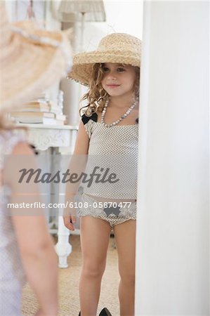 Portrait of a little girl dressed like her mother in oversized accessories  - Stock Photo - Masterfile - Premium Royalty-Free, Code: 6108-05874909