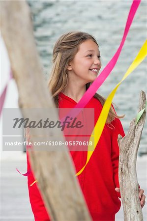 Girl standing near a decorated tree and smiling