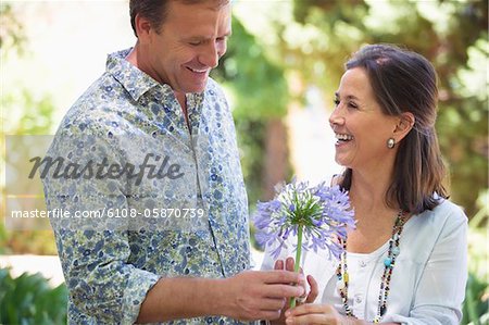 Man giving flower to his mother and smiling