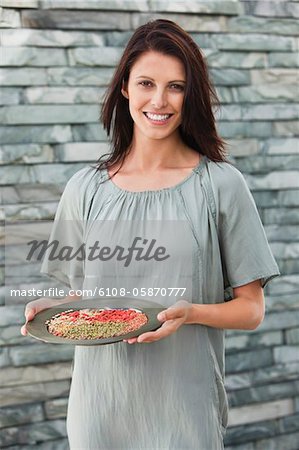 Portrait of a woman holding a plate of herbs