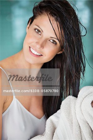 Portrait of a woman drying her hair with a towel