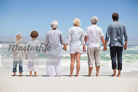 Rear view of a family looking at sea view from beach