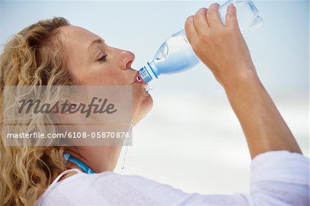 Side profile of a beautiful woman drinking purified water