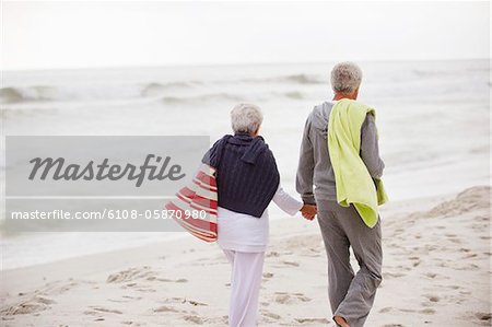 Rear view of a senior couple walking on the beach