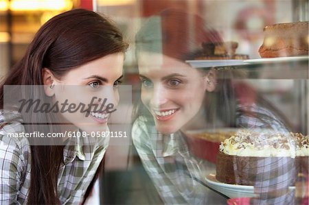 Woman looking at cakes in a bakery window