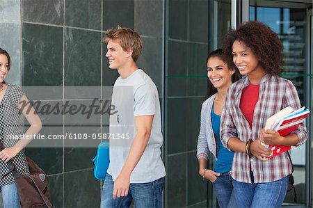Smiling university students walking in campus