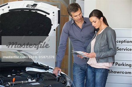 Couple looking at a car catalog in showroom
