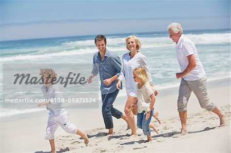 Multi generation family running on the beach