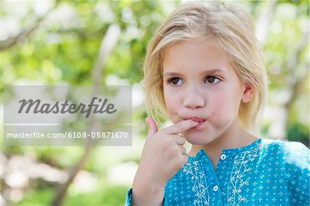 Close-up of a cute girl eating something outdoors