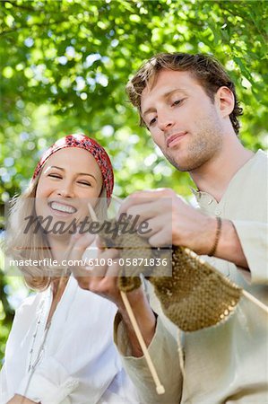 Young couple knitting together and smiling