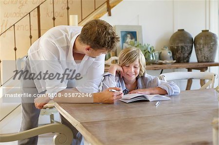 Man teaching his son at house