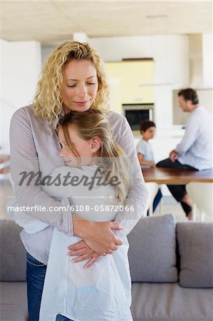 Mother hugging her daughter and smiling